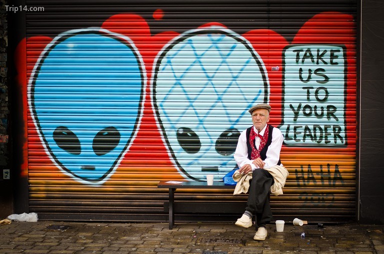 Một ông già ngồi ngoài bức tranh tường nghệ thuật đường phố - Trip14.com